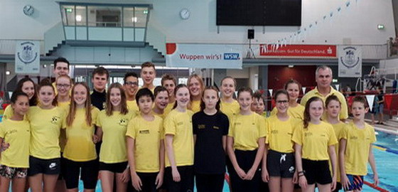 Foto mit Schwimmerinnen, Schwimmer und Trainer