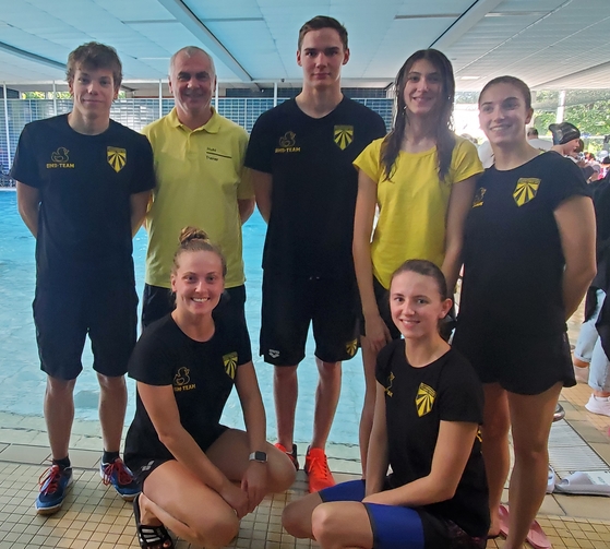 Foto mit Schwimmerinnen, Schwimmer und Trainer